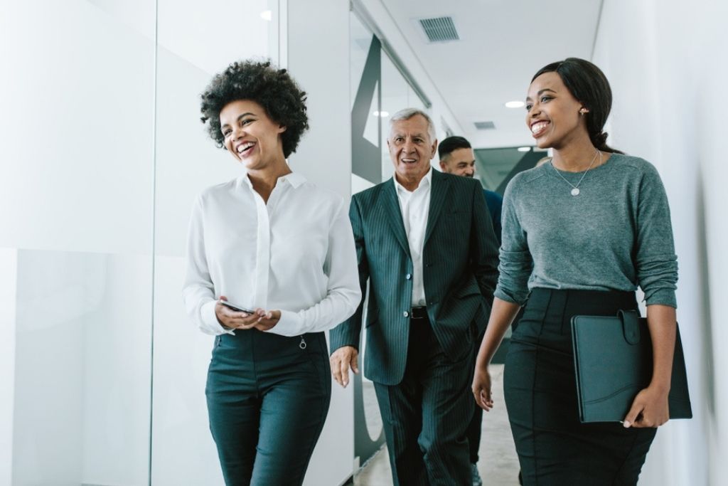 Male and female business managers walk down a hallway