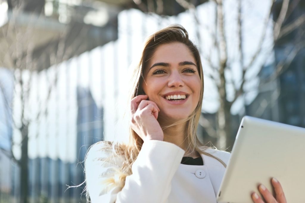 A female Communications major talks on a cell phone and holds a tablet