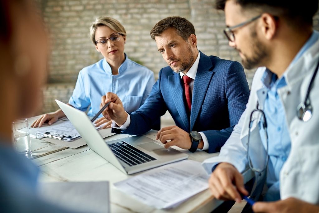 A male health services administrator meets with doctors