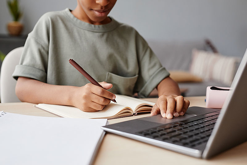 young man working on homework on laptop