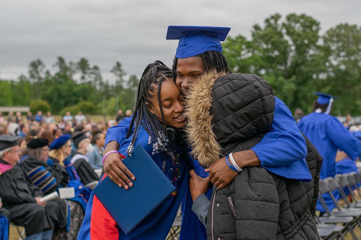 student hugging family members