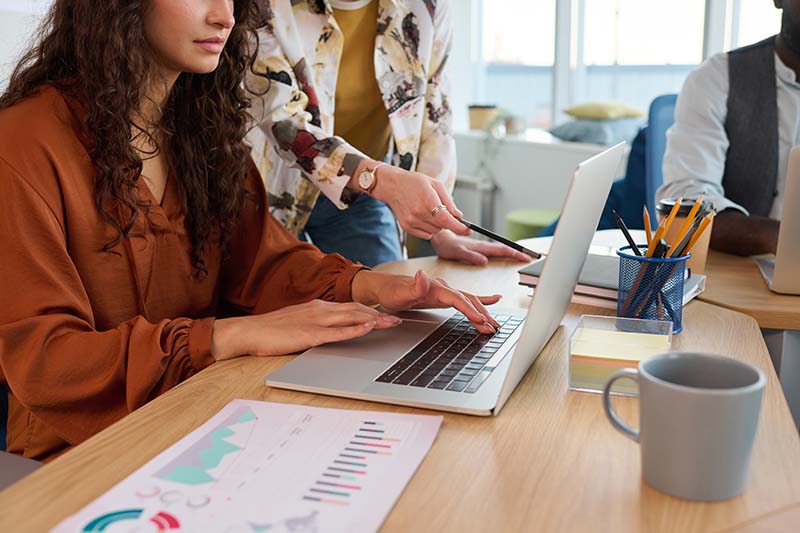 young businesswoman with pencil pointing at screen