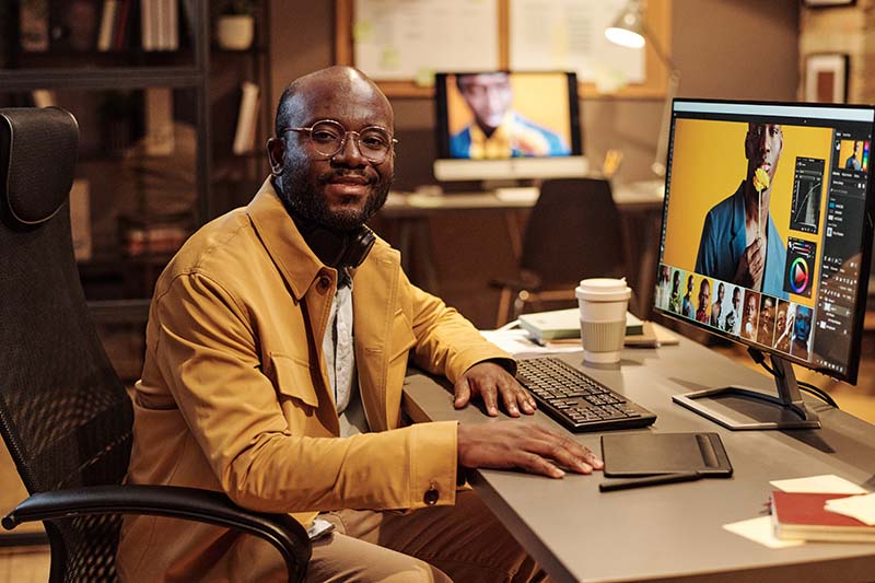 graphic designer sitting at his desk in front of computer