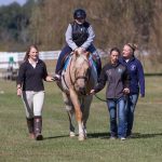 SAU equestrian students walking next to youth on horse