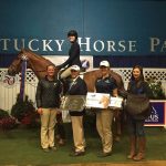 Small group of people holding awards as rider sits atop horse